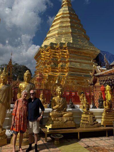 Older couple from the UK smiling at a temple in Thaialnd